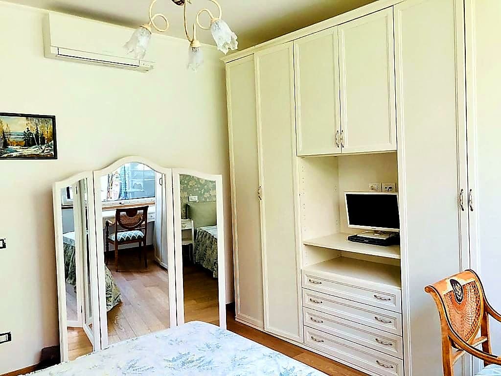 L'altro lato della camera matrimoniale · grande armadio a parete bianco, climatizzatore Mitsubishi, specchio trittico vintage