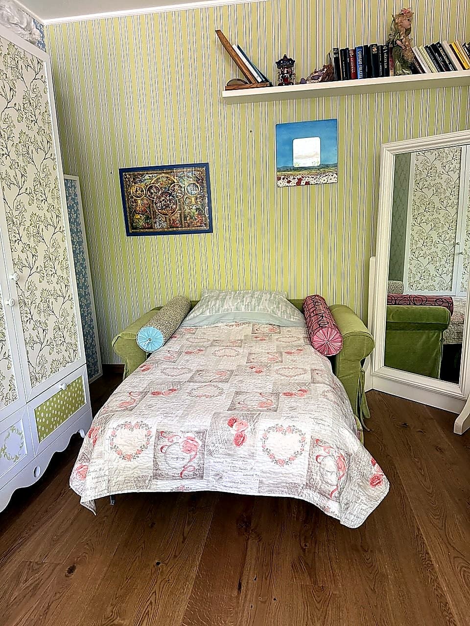 Lo stesso divano della seconda camera aperto in letto, già preparato con copriletto trapuntato a cuori